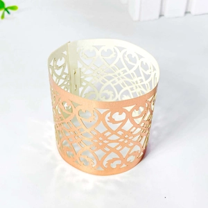 Close-up of laser-cut rose gold napkin ring featuring elegant scrollwork patterns