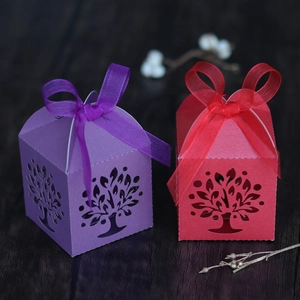 Detail showing laser-cut Tree of Life patterns on purple and red gift boxes with ribbons