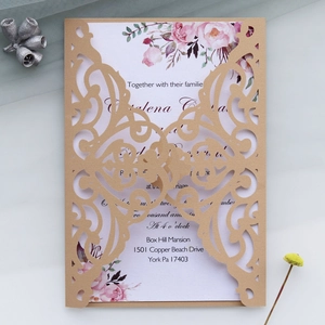 Detail of laser-cut wedding invitation with golden hollow spiral pattern and rose card
