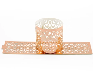 Macro view of rose gold heart-shaped laser-cut napkin rings with reflective metallic finish