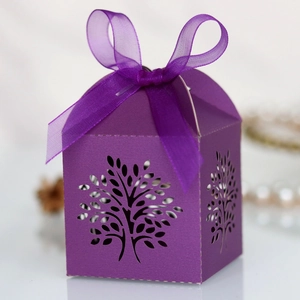 Macro detail of purple laser-cut tree design on luxury gift box with ribbon bow