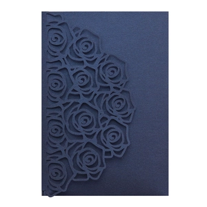 Detail showing laser-cut rose patterns on a dark blue pearlescent paper invitation