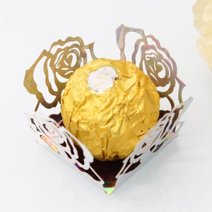 Vue macro d'une boîte à bonbons rose argentée découpée au laser avec chocolat doré