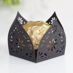 Detail of laser-cut black candy box with elegant floral hollow patterns for weddings