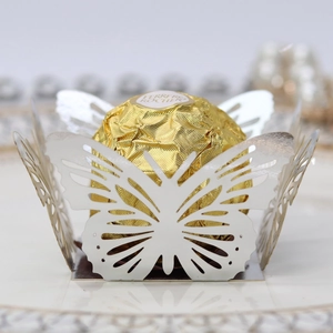 Close-up of laser-cut white butterfly lace hollow wrappers for chocolate and candy
