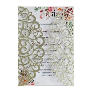 Detail of laser-cut wedding invitation with gold glitter texture and floral pattern
