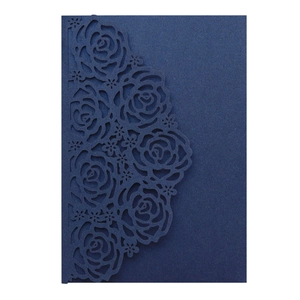 Detail of laser-cut rose floral design on dark blue pearlescent paper invitation cover