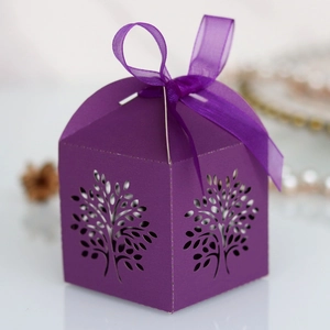Close-up of laser-cut tree design on purple gift box with chiffon ribbon and bow