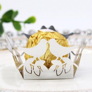 Detail showing white laser cut candy wrapper with bird design and chocolate truffles