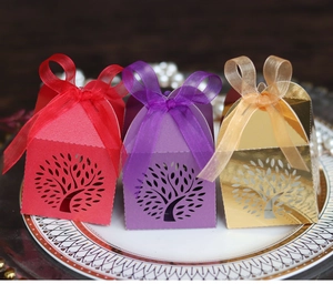 Detail of laser-cut tree of life candy boxes in red, purple, and gold with ribbon