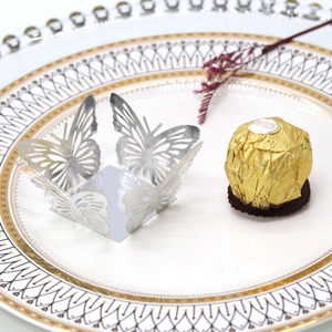 Silver hollow butterfly laser-cut decor on a white porcelain plate for chocolate