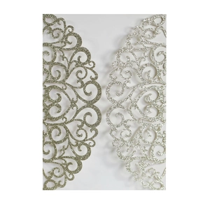 Macro shot of glitter laser-cut invitation card with heart and scroll patterns