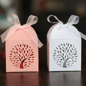 Detailed laser-cut tree of life candy boxes in pink and white with organza ribbons