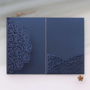 Detail of navy blue laser-cut rose floral invitation cover in premium pearlescent paper
