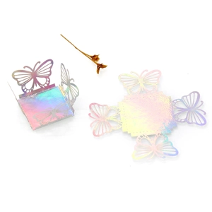 Detail of laser-cut iridescent butterfly favor boxes with holographic reflection
