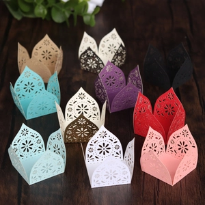 Close-up of laser-cut paper candy boxes with elegant floral hollow patterns for weddings
