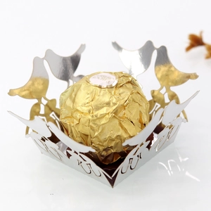 Detailed close-up of a silver laser-cut candy box with intricate bird and floral patterns