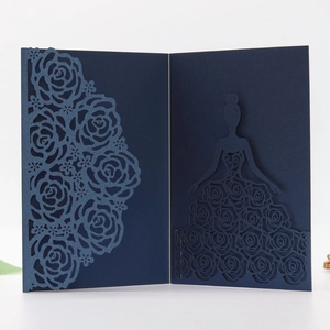 Macro shot of dark blue laser-cut wedding invitation featuring rose patterns and girl silhouette