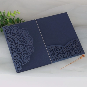 Detailed laser-cut rose patterns on a navy blue pearlescent paper wedding invitation cover