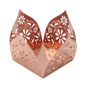 Macro view of rose gold laser-cut floral pattern on mirror finish candy box wrapper