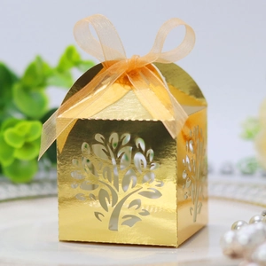 Detail of laser-cut golden tree candy box with elegant ribbon for wedding parties