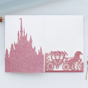 Detail der glitzernden rosa Laser-Hochzeitseinladung mit Schloss und Kürbiskutsche