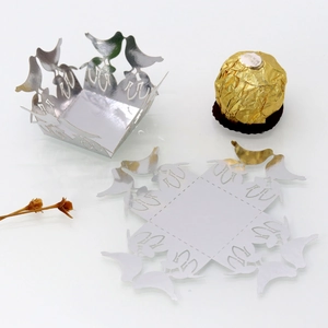 Detailed laser-cut silver paper candy box featuring intricate bird and floral patterns