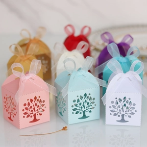 Detailed laser-cut Tree of Life candy boxes in various colors with organza ribbons