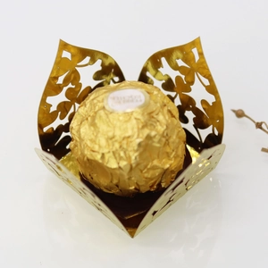 Macro view of golden laser-cut clover candy box with intricate heart petal design