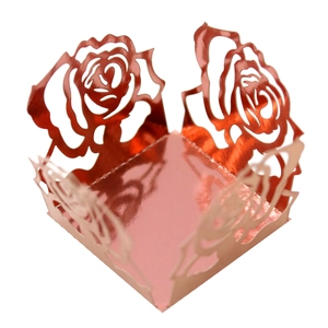 Vue détaillée de la boîte à bonbons ajourée en métal rose doré avec motif de rose