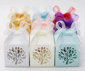 Detail of tree laser-cut hollow candy boxes with chiffon ribbons in various pearlescent colors