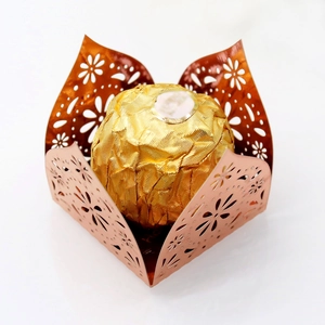 Close-up of laser-cut rose gold chocolate tray with intricate floral hollow patterns
