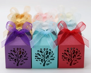 Detail of laser-cut tree design on hollow candy gift boxes with elegant organza ribbons