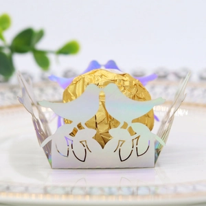 Macro detail of laser-cut bird hollow candy wrapper with iridescent laser effect on white plate