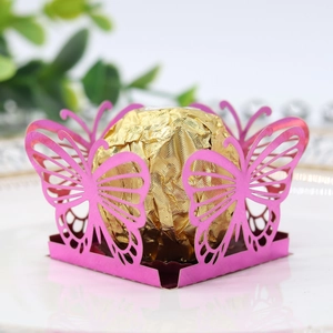 Detailed view of a laser-cut pink butterfly favor box with a gold foil chocolate