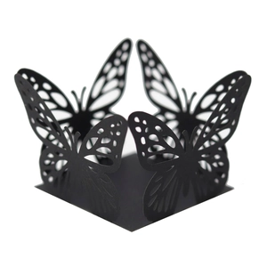 Intricate laser-cut black butterfly cupcake wrapper with delicate hollowed paper texture