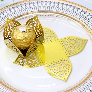 Macro detail of gold laser-cut floral chocolate liners for festive party candy packaging