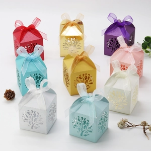 Macro detail of laser-cut tree gift boxes in multiple colors with organza ribbon bows