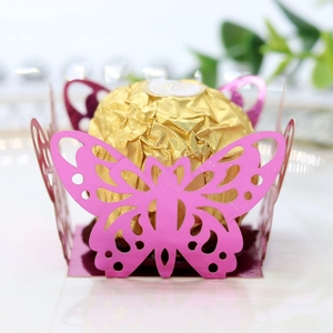 Macro detail of laser-cut pink butterfly candy holder with Ferrero Rocher chocolate
