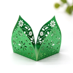Detailed macro view of laser-cut green pearlescent paper candy box with floral patterns