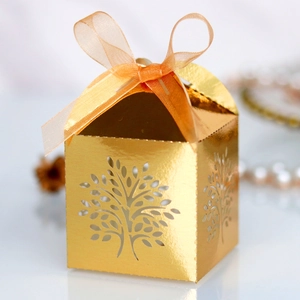 Close-up of golden hollow tree candy box with an orange organza ribbon bow