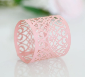 Close-up of laser-cut rose gold napkin ring with intricate floral patterns
