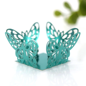 Macro shot of laser-cut teal metallic paper butterfly favor box for wedding parties