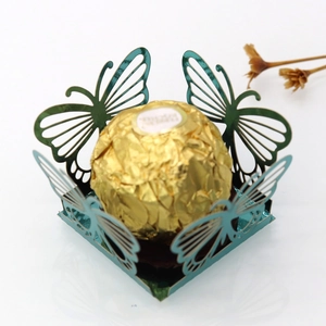 Macro detail of laser-cut butterfly hollow candy box with teal metallic mirror finish