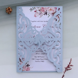 Macro detail of laser-cut vine texture on lavender wedding invitation with floral card