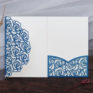 Macro view of laser-cut rose hollow pattern on royal blue glitter cardstock invitation