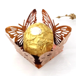 Macro shot of rose gold laser-cut butterfly wrapper with metallic finish for chocolates