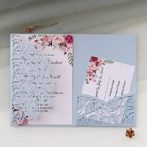 Detailed laser-cut light blue floral wedding invitation with rose pattern inserts