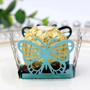 Detailed laser-cut blue butterfly candy holder with gold foil chocolate on a plate