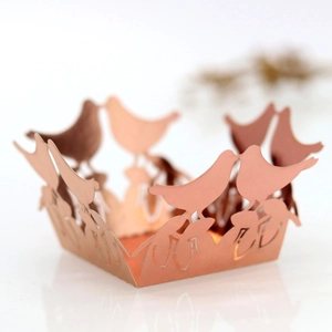Close-up of rose gold laser-cut hollow bird candy box with intricate lace patterns